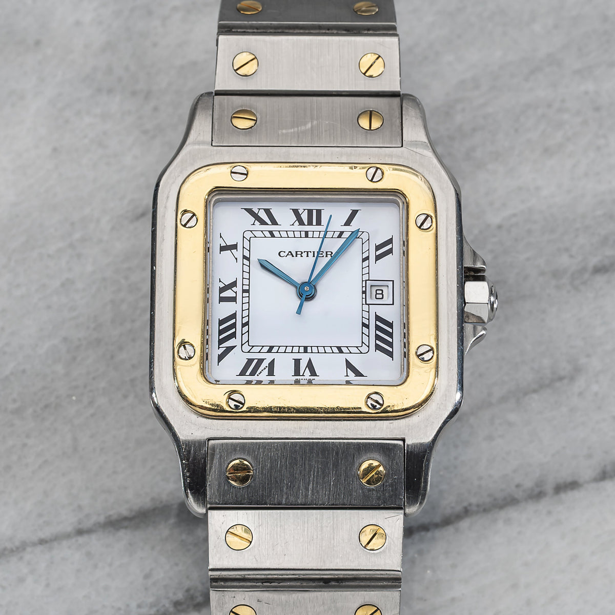 Santos 2961 in steel and yellow gold with the white Roman dial, blued sword hands, date at three and blue cabochon crown. · Photo: Danny's Vintage Watches · © Danny's Vintage Watches, used with permission · Source: https://dannysvintagewatches.com/products/cartier-santos-2961-white-roman-dial