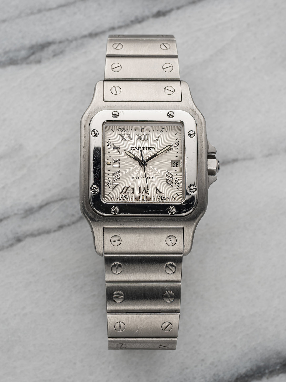 Steel Santos Galbée 2319 on the wrist, silver guilloché dial with Roman numerals and date. · Photo: Danny's Vintage Watches · © Danny's Vintage Watches, used with permission · Source: https://dannysvintagewatches.com/products/cartier-santos-2319-guilloche-dial-4