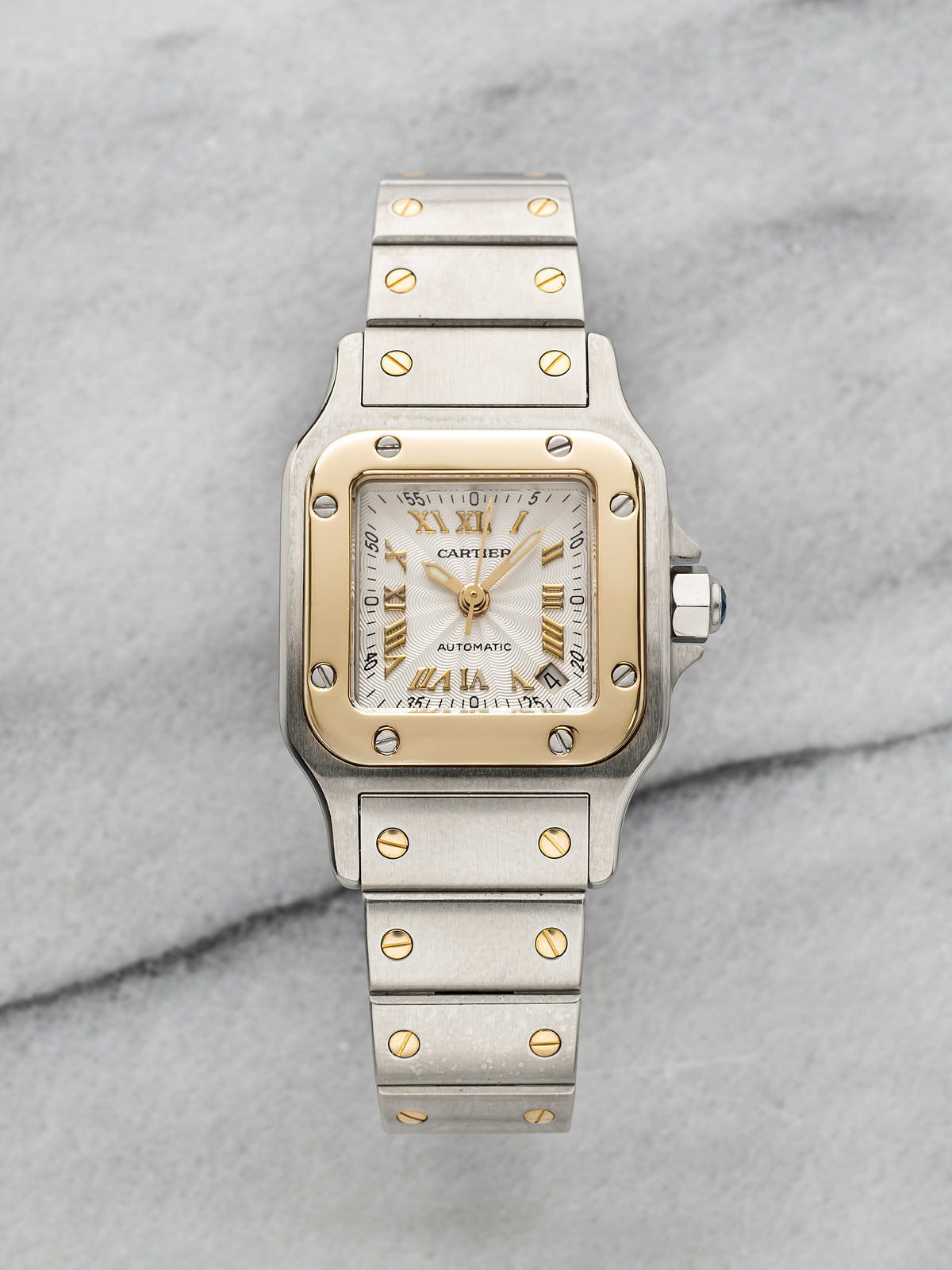 Two-tone Santos 2423 whose guilloché dial has applied gold Roman numerals and gold hands. · Photo: Danny's Vintage Watches · © Danny's Vintage Watches, used with permission · Source: https://dannysvintagewatches.com/products/cartier-santos-2423-two-tone-guilloche-dial
